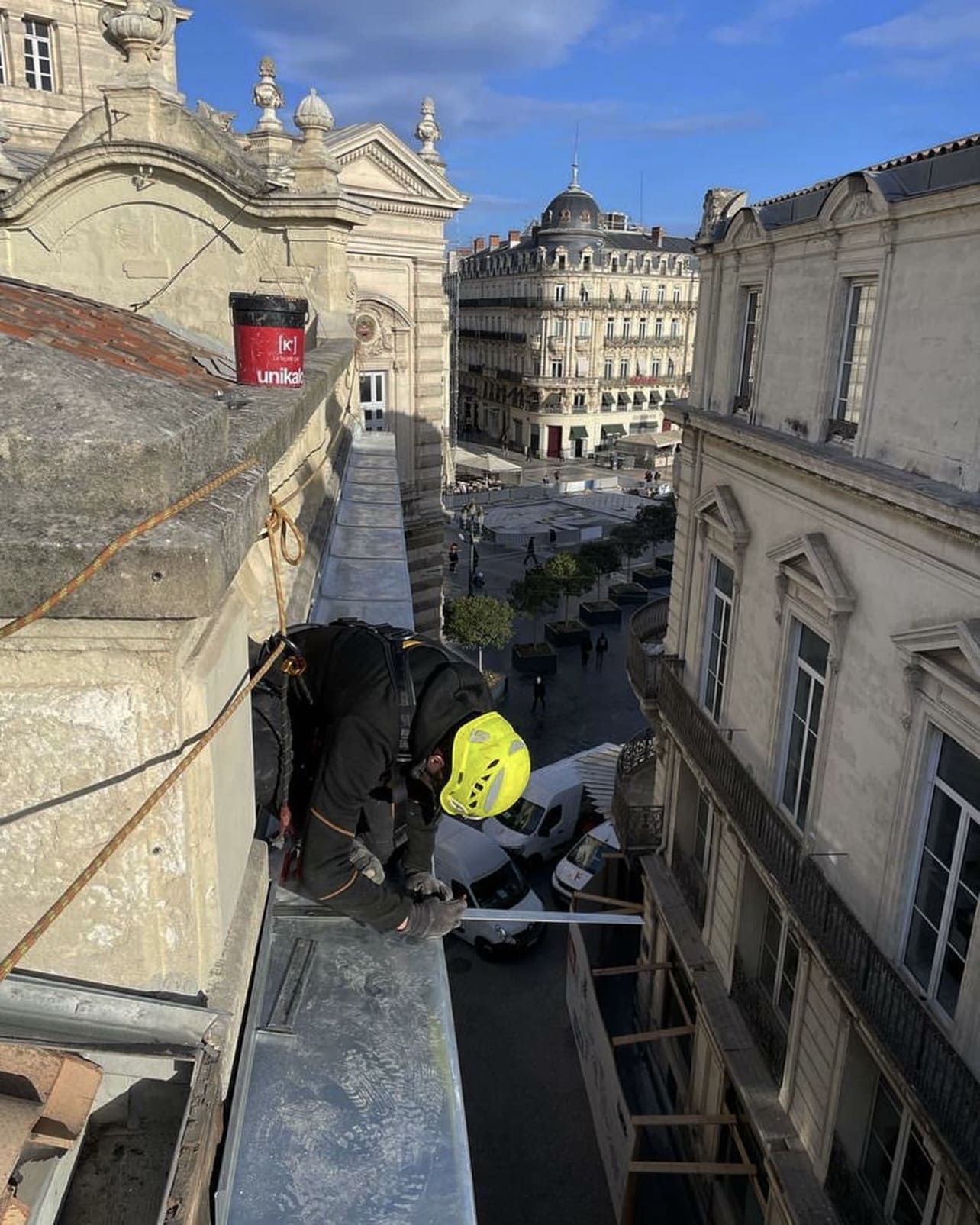 Couvreur zingueur façonnant du zinc en hauteur sur un chantier en centre-ville de Montpellier